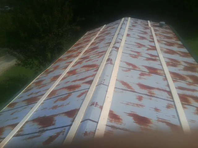 Rusted metal roof panels with new wood purlins before replacement — Storm Damage Roof Repair in Pensacola by Roofing Brothers