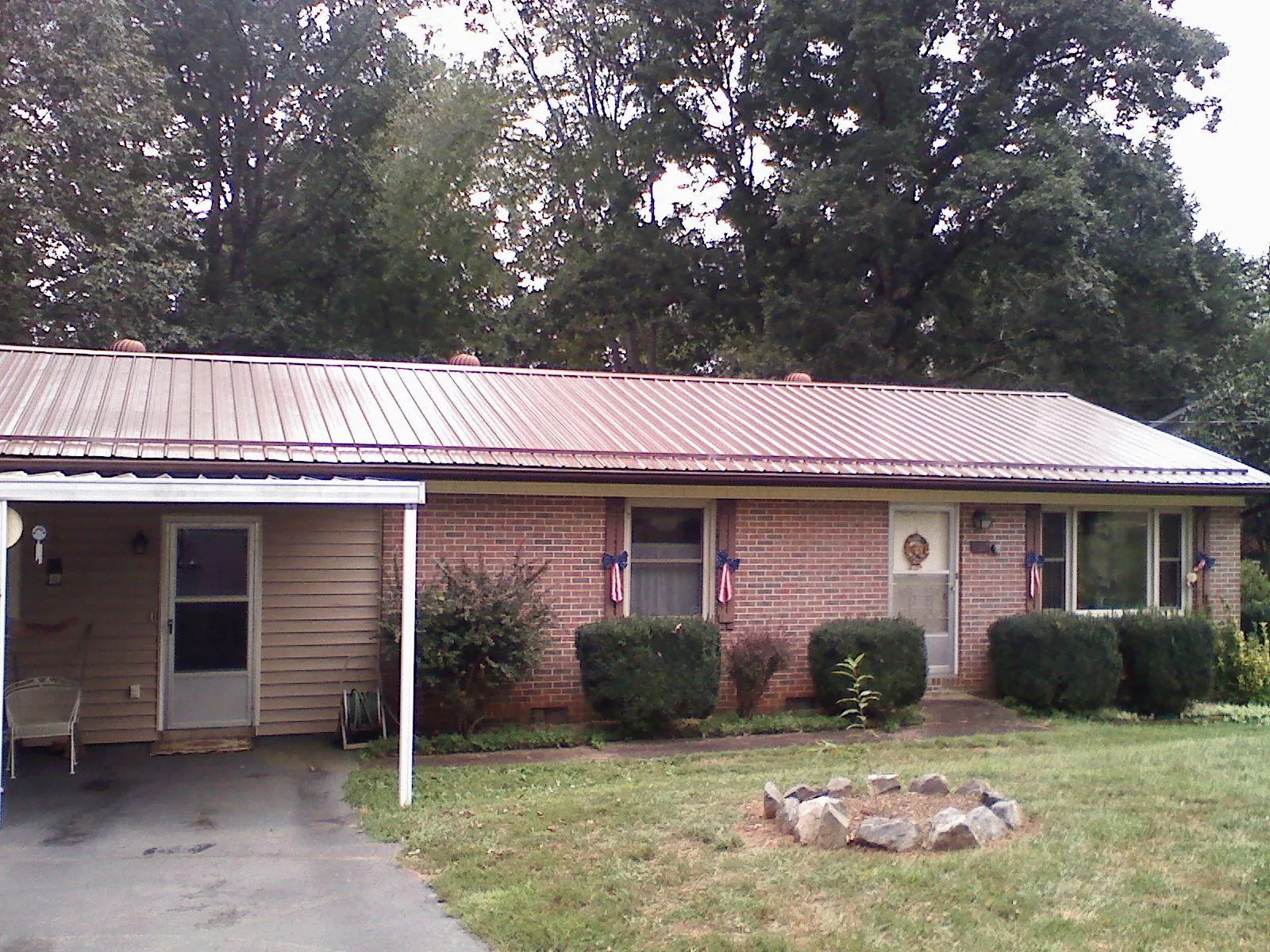 Bronze metal roof and carport on a brick ranch home — Roof Repair work by our crew in Pensacola