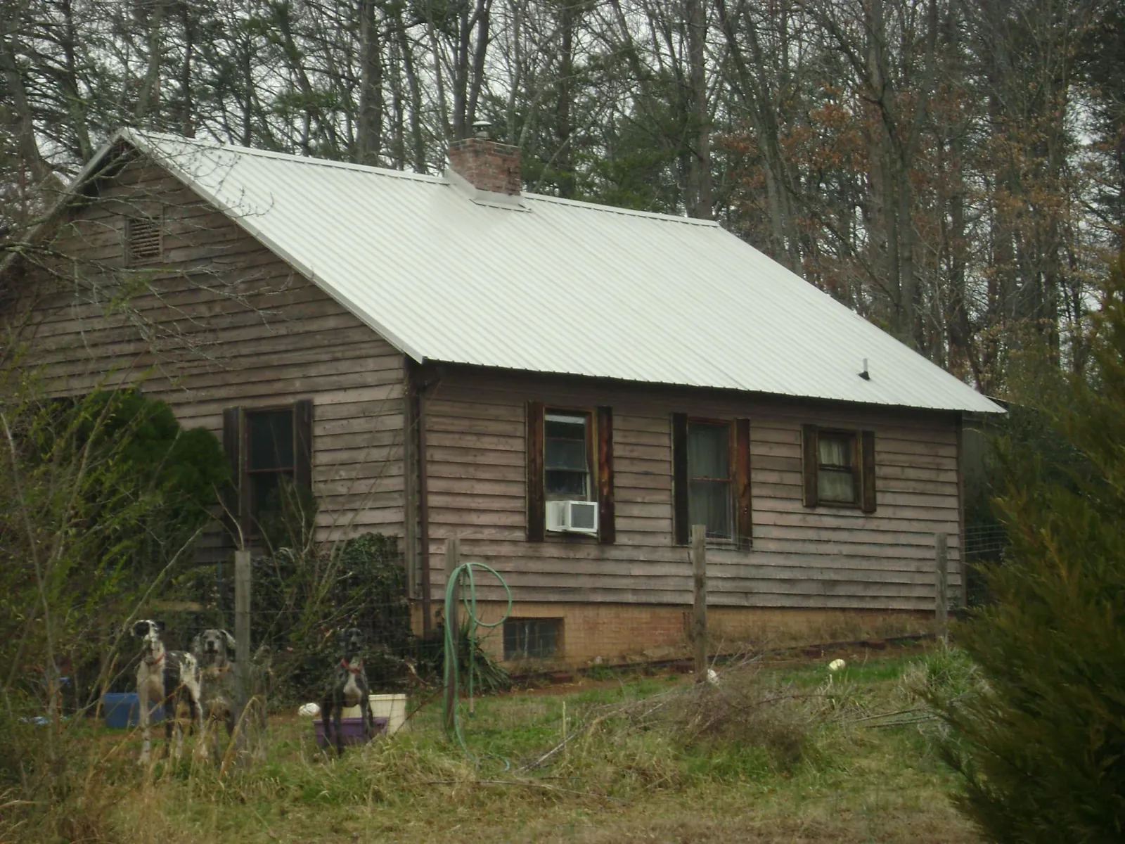 White metal roof on an old wood sided farmhouse, from a Metal Roof Installation job in Pensacola